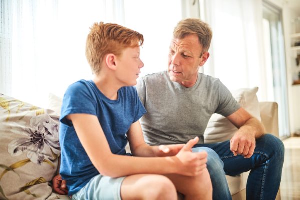 Shot of a mature father and his son having a disagreement at home